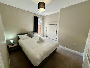 a bedroom with a large white bed with a window at 2br Ormeau central in Belfast