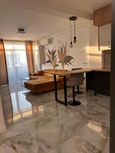 a kitchen and living room with a table and a couch at Apartament Urban Chic in Sebeş