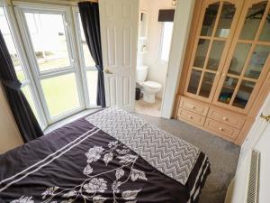 a bedroom with a bed and a bathroom with a window at Towervans Z11 in Mablethorpe