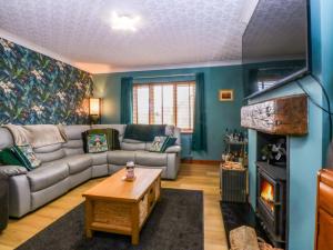 a living room with a couch and a fireplace at 36 Cae Rhos in Holyhead