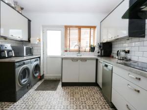 a kitchen with a sink and a washing machine at 36 Cae Rhos in Holyhead