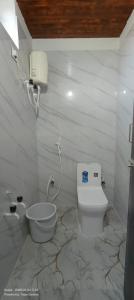 a white bathroom with a toilet and a sink at Srinivasa Hotel in Narasingāpuram