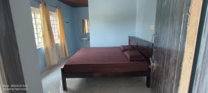 a bedroom with a bed in a room with a window at Srinivasa Hotel in Narasingāpuram +4 photos