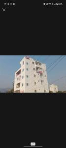 a picture of a tall white building in two pictures at Srinivasa Hotel in Narasingāpuram