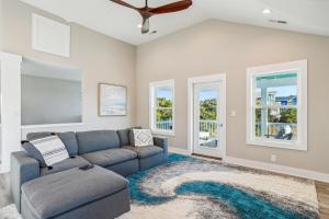 a living room with a blue couch and windows at 4920 - Stress Less II in Kitty Hawk