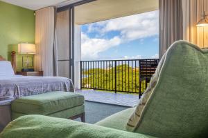 a hotel room with a bed and a balcony with a view at Kaanapali Shores 640 in Kahana