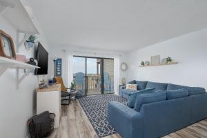 a living room with a blue couch in a room at 2971 - Seabbatical in Duck