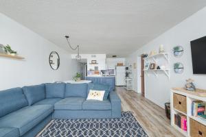 a living room with a blue couch and a kitchen at 2971 - Seabbatical in Duck +20 photos