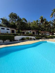 a large swimming pool in front of a building at Bitingui Praia Hotel in Japaratinga