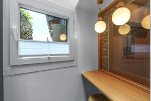 a window in a room with a wooden shelf and lights at SEBASTIAN Apartamentos in Getaria