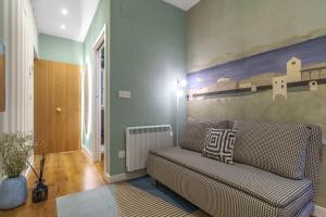 a living room with a couch and a painting on the wall at SEBASTIAN Apartamentos in Getaria