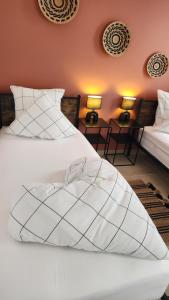 a bedroom with two beds and two tables with lamps at La maison des Vignes est climatisée avec ménage, draps et serviettes inclus in Tabanac +12 photos