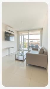 a white living room with a couch and a table at START Villa Morra Rent Apartments in Asunción