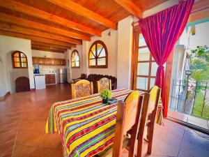 a dining room table with a colorful striped table cloth at Hostal Dulces Sueños in Panajachel