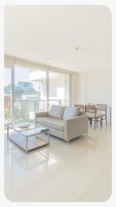 a white living room with a couch and a table at START Villa Morra Rent Apartments in Asunción