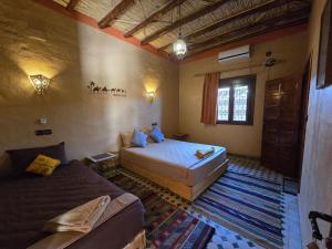 a large bedroom with two beds and a window at Riad Berber in Merzouga
