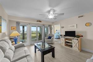 a living room with a couch and a tv at 7081 - Sea View in Rodanthe