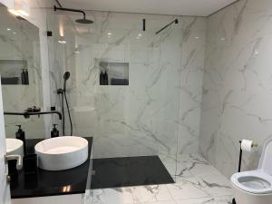 a bathroom with a shower and a sink and a toilet at Casa aOrta Apartments in Faro +39 photos