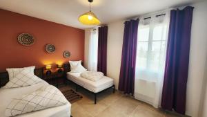 a room with two beds and a window at La maison des Vignes est climatisée avec ménage, draps et serviettes inclus in Tabanac