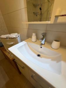 a bathroom with a white sink and a mirror at Ferienwohnung in Neudenau