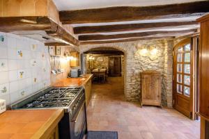a kitchen with a stove and a stone wall at Catalunya Casas Unique sanctuary with extra large pool! in Santa Oliva