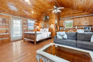 a living room with a bed and a couch at Hillside Hideout Log Cabin For 2! Cabin 10 in Fancy Gap