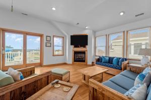 a living room with blue couches and a tv at 4744 - Sandy Beaches in Kitty Hawk Beach