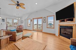 a living room with a fireplace and a flat screen tv at 4744 - Sandy Beaches in Kitty Hawk Beach +45 photos