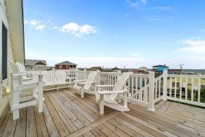 a deck with white chairs and a view of the ocean at 4744 - Sandy Beaches in Kitty Hawk Beach