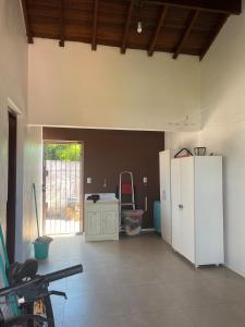 a living room with a white refrigerator and a window at Comfortable home, close to everything! in Caçapava do Sul