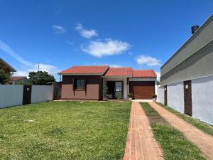 a house with a brick walkway in front of a yard at Comfortable home, close to everything! in Caçapava do Sul
