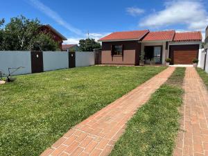 a house with a brick pathway in front of a yard at Comfortable home, close to everything! in Caçapava do Sul