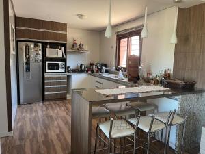 a kitchen with a large island with bar stools at Comfortable home, close to everything! in Caçapava do Sul