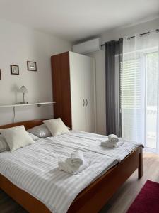 a bedroom with a large bed with towels on it at Guesthouse Kurelic Rab in Kampor