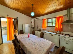 a kitchen with a table and a kitchen with orange curtains at La Pantera in San Antonio de Arredondo
