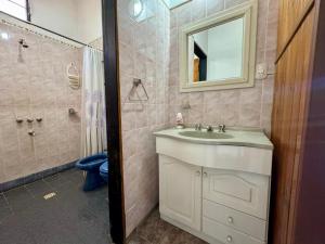 a bathroom with a sink and a shower with a mirror at La Pantera in San Antonio de Arredondo
