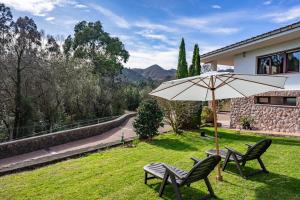 a patio with two chairs and an umbrella at Vivienda Vacacional La Seronda in Ribadesella