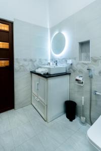 a white bathroom with a sink and a mirror at Peak Heaven Apartments in Negombo +53 photos