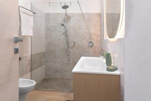 a bathroom with a shower and a sink and a toilet at Terra e Mare Apartments II- Terra in Sorso