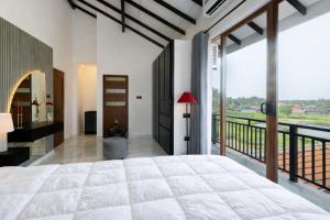 a bedroom with a large bed and a balcony at Peak Heaven Apartments in Negombo