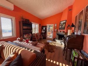 a living room with orange walls and a couch and a fireplace at Los Jazmines in Agaete