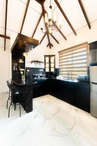 a kitchen with black cabinets and a table at Peak Heaven Apartments in Negombo