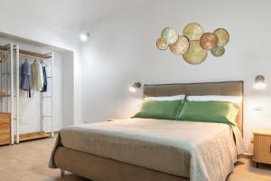 a bedroom with a large bed with green pillows at Terra e Mare Apartments II- Terra in Sorso