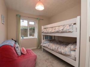 a bedroom with two bunk beds and a window at Seashells at Runswick Lodge in Saltburn-by-the-Sea