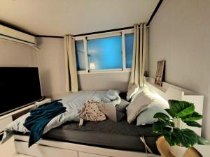 a bedroom with a bed with a large window at Dodahm guesthouse stay in Incheon