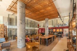 ein Restaurant mit Holzdecken, Tischen und Stühlen in der Unterkunft The Hub Urban Hotel in Asunción
