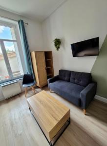 a living room with a couch and a coffee table at Appartement à thermal in Nancy