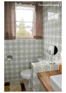 a bathroom with a toilet and a window at Ferienwohnung Janssen Herborn in Herborn +20 photos