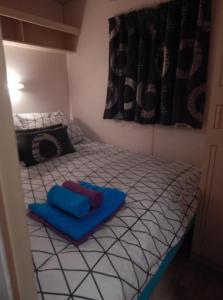 a small bedroom with a bed with blue sheets at L'ancyze in Le Torp-Mesnil +5 photos