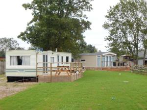 a mobile home with a picnic table in a yard at L'ancyze in Le Torp-Mesnil